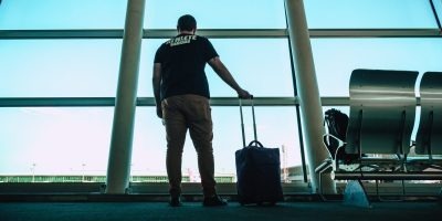 A traveler stands at an airport terminal